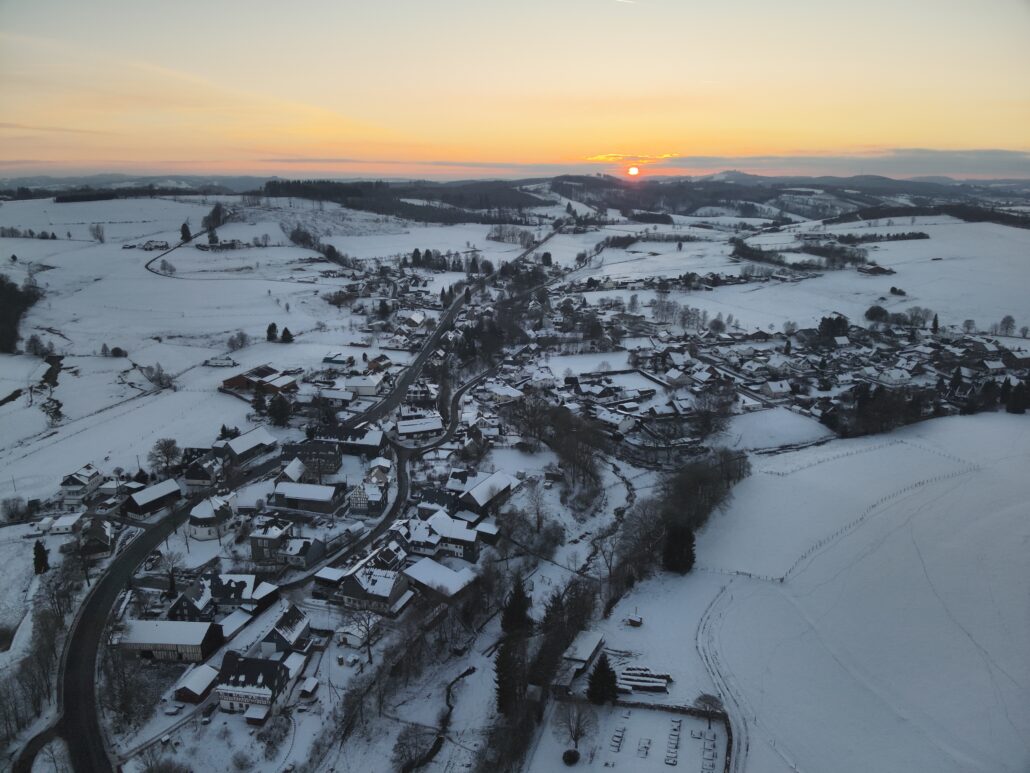 Verschneites Weidenhausen bei Sonnenuntergang aus der Luft