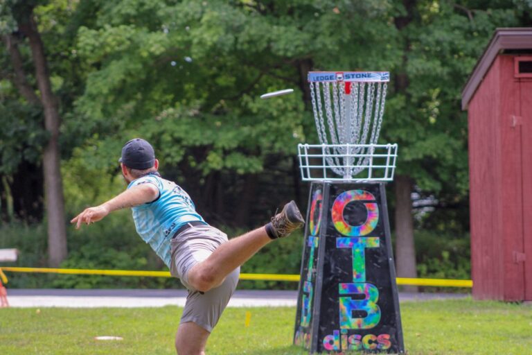 Spieler wirft eine Scheibe auf einen Disc-Golf-Korb