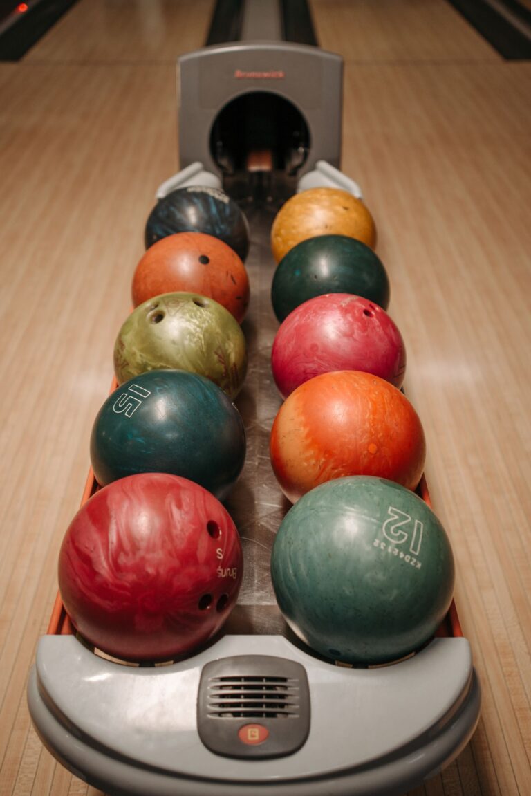 Bunte Bowlingkugeln im Kugelrücklauf an einer Bowlingbahn