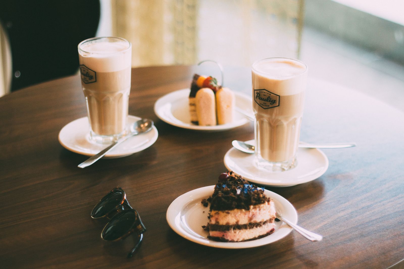 Latte macchiato und Kuchen auf einem Cafétisch